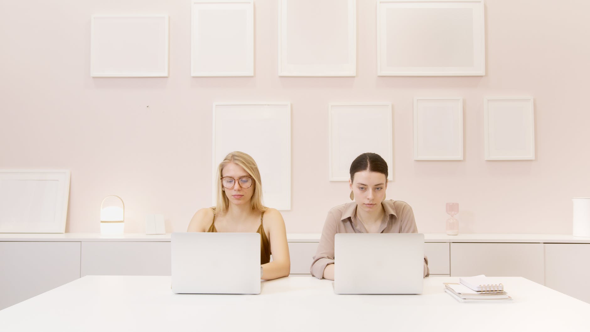 two women using laptop computer on table