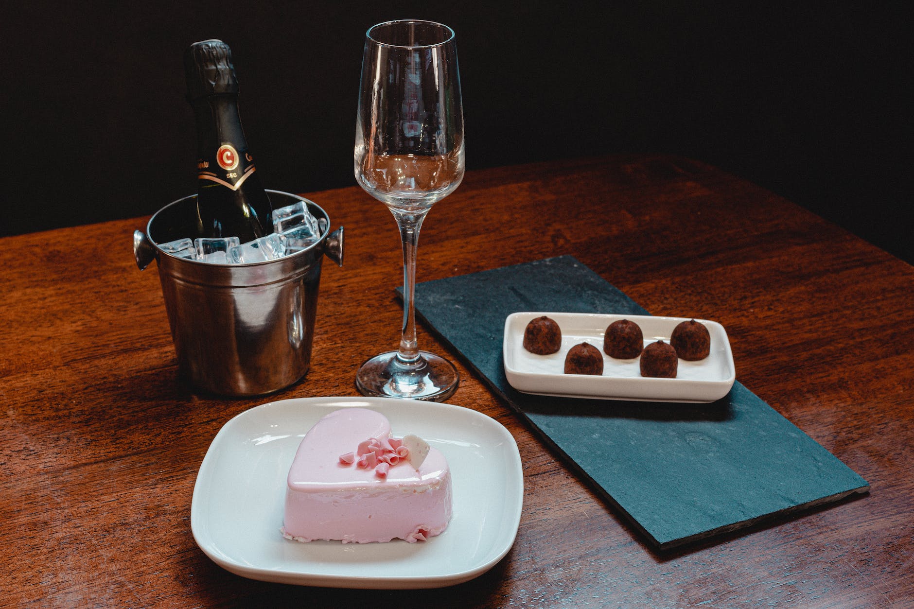 strawberry cake on white ceramic plate beside the champange glass